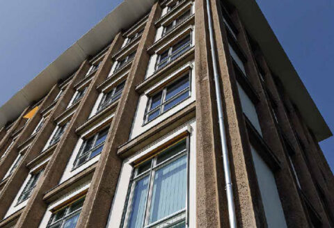 Fassade eines mehrgeschossigen Hauses mit braunen Ziegeln